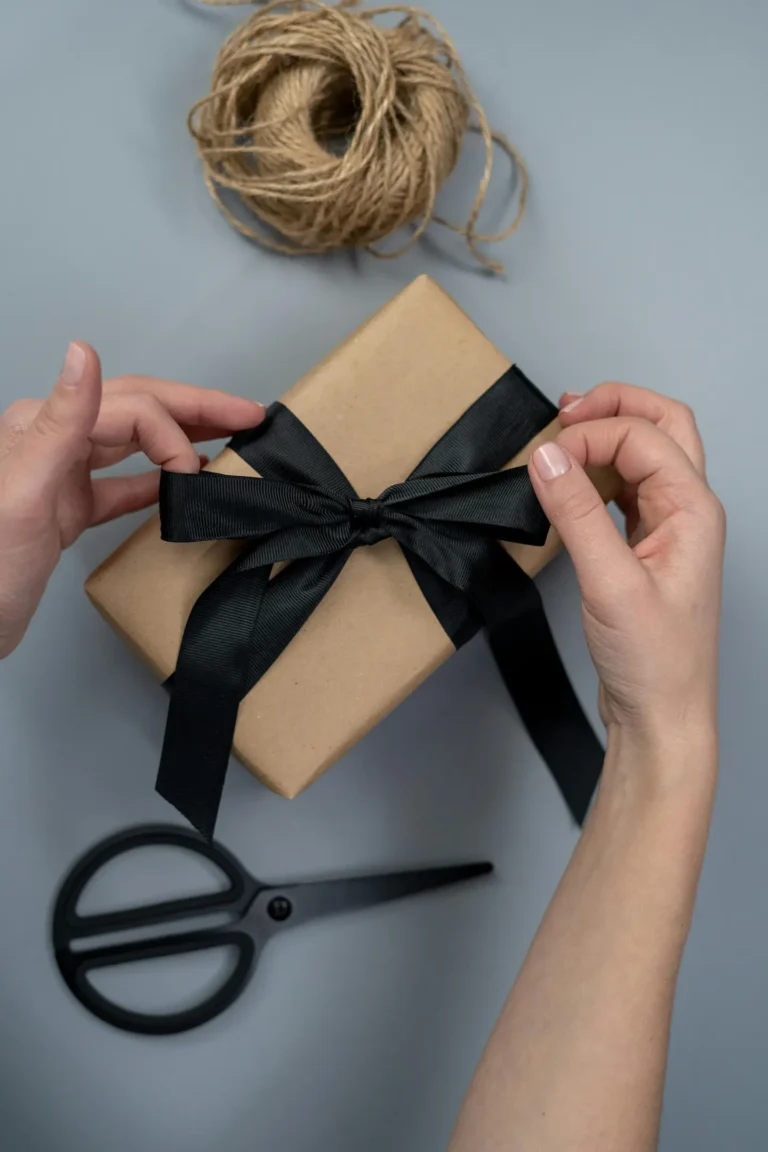 Hands tying a bow around a present