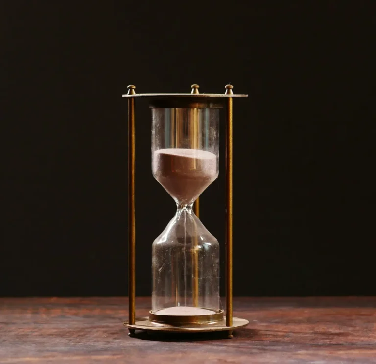 An hourglass on a wooden table