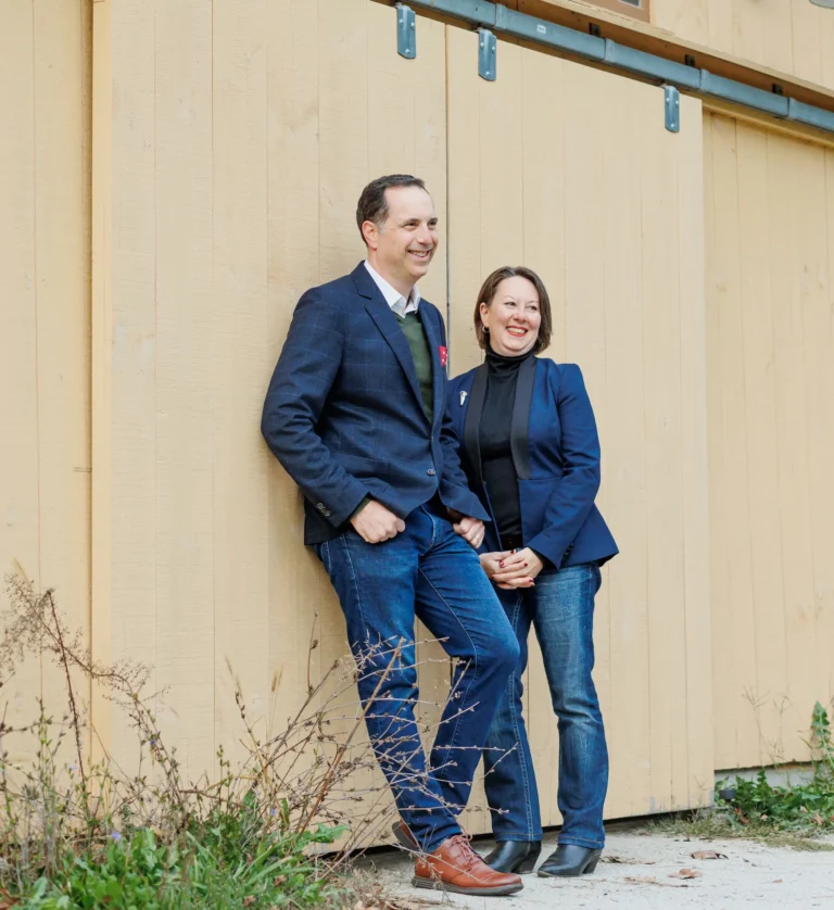 Joe and Marie Schick leaning against a barn